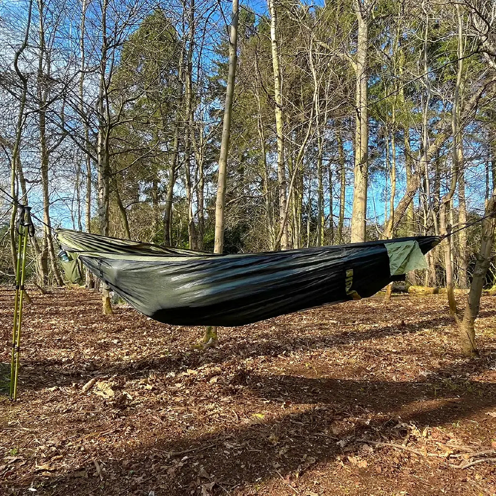 DD Recycled Frontline Hammock suspended between trees, made from recycled plastic bottles, perfect for outdoor adventures. DD Recycled Frontline Hammock suspended between trees, made from recycled plastic bottles, perfect for outdoor adventures.