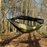 DD Recycled Frontline Hammock hanging in the woods, made from recycled plastic bottles, featuring bugproof design.