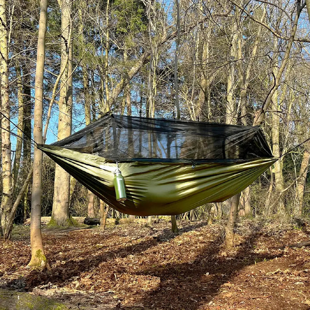 DD Recycled Frontline Hammock set up in a forest with bug netting, showcasing its eco-friendly design made from recycled plastic. DD Recycled Frontline Hammock set up in a forest with bug netting, showcasing its eco-friendly design made from recycled plastic.