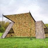 DD A-Frame Tent in DD Multicam pattern set up outdoors, blending into the natural woodland environment.