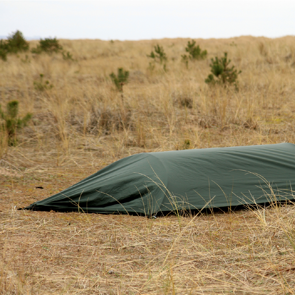 DD Hammocks Superlight Jungle Hammock set up in a grassy outdoor area, showcasing its green waterproof layer. DD Hammocks Superlight Jungle Hammock set up in a grassy outdoor area, showcasing its green waterproof layer.