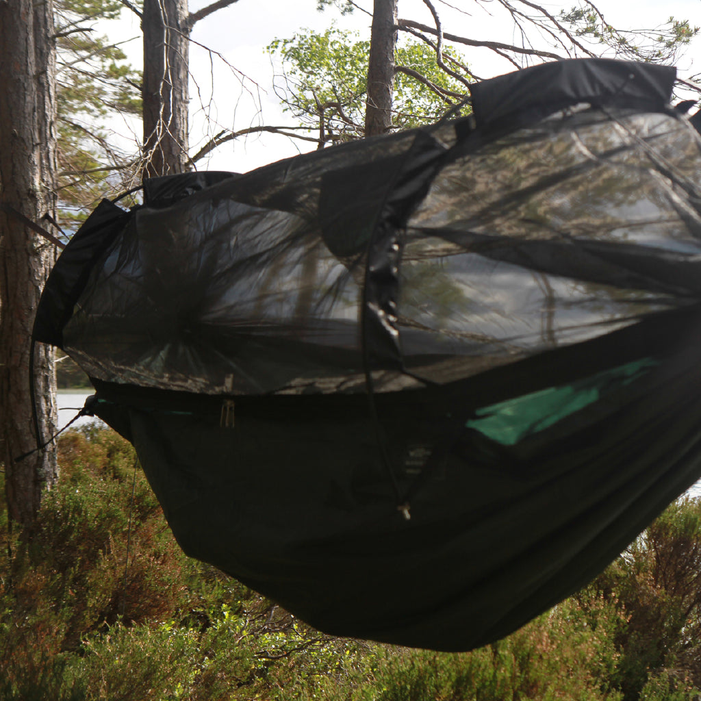 DD Hammocks SuperLight Jungle Hammock featuring a detachable mosquito net in a natural setting. DD Hammocks SuperLight Jungle Hammock featuring a detachable mosquito net in a natural setting.