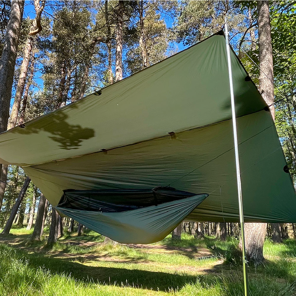 DD Superlight Frontline Hammock set up in a forest, showcasing its lightweight design and protective tarp overhead. DD Superlight Frontline Hammock set up in a forest, showcasing its lightweight design and protective tarp overhead.