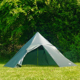 DD Superlight Pyramid Tent set up in a green field with trees, showcasing a spacious design for solo camping.