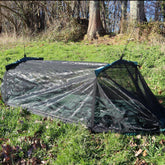 DD Travel Hammock / Bivi with mosquito net set up on grass, ideal for camping and bivouacking.