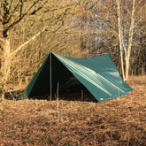 DD Hammocks 5x5 tarp set up in a wooded area, providing a dry cover solution for outdoor activities.