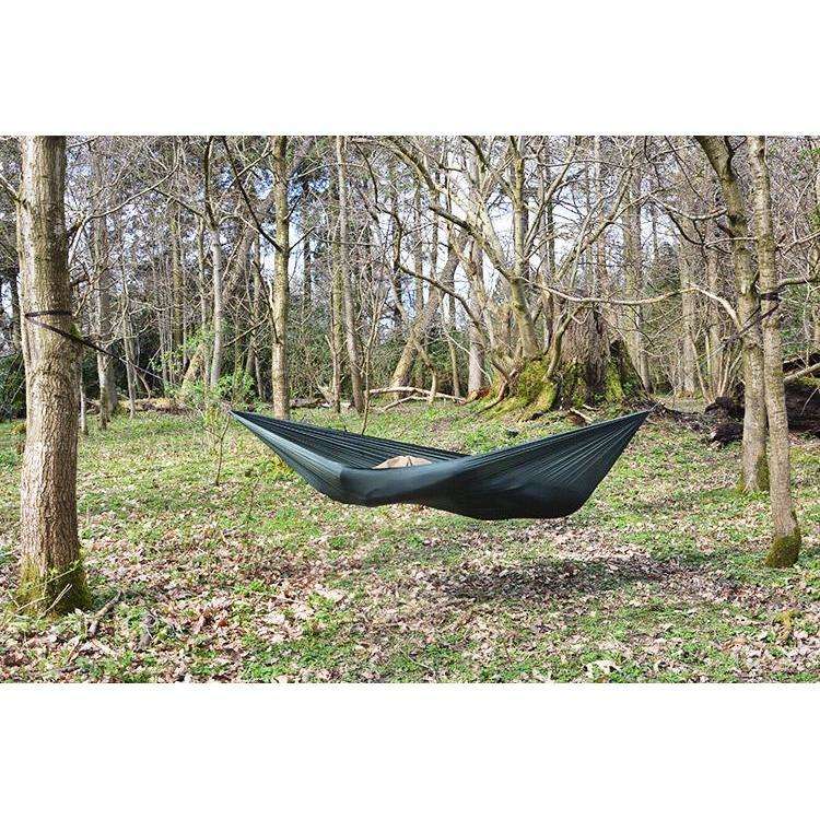 DD Superlight Winter Hammock set up between trees in a tranquil outdoor setting, ideal for camping. DD Superlight Winter Hammock set up between trees in a tranquil outdoor setting, ideal for camping.