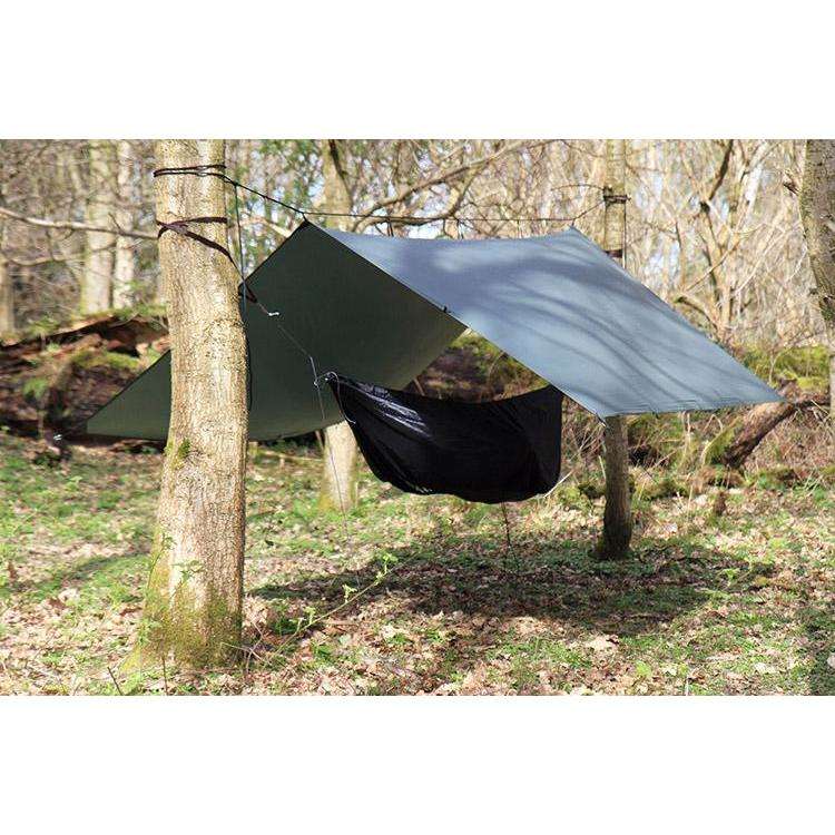 DD Superlight Hammock combo setup with tarp and hammock between trees in a forest setting. DD Superlight Hammock combo setup with tarp and hammock between trees in a forest setting.