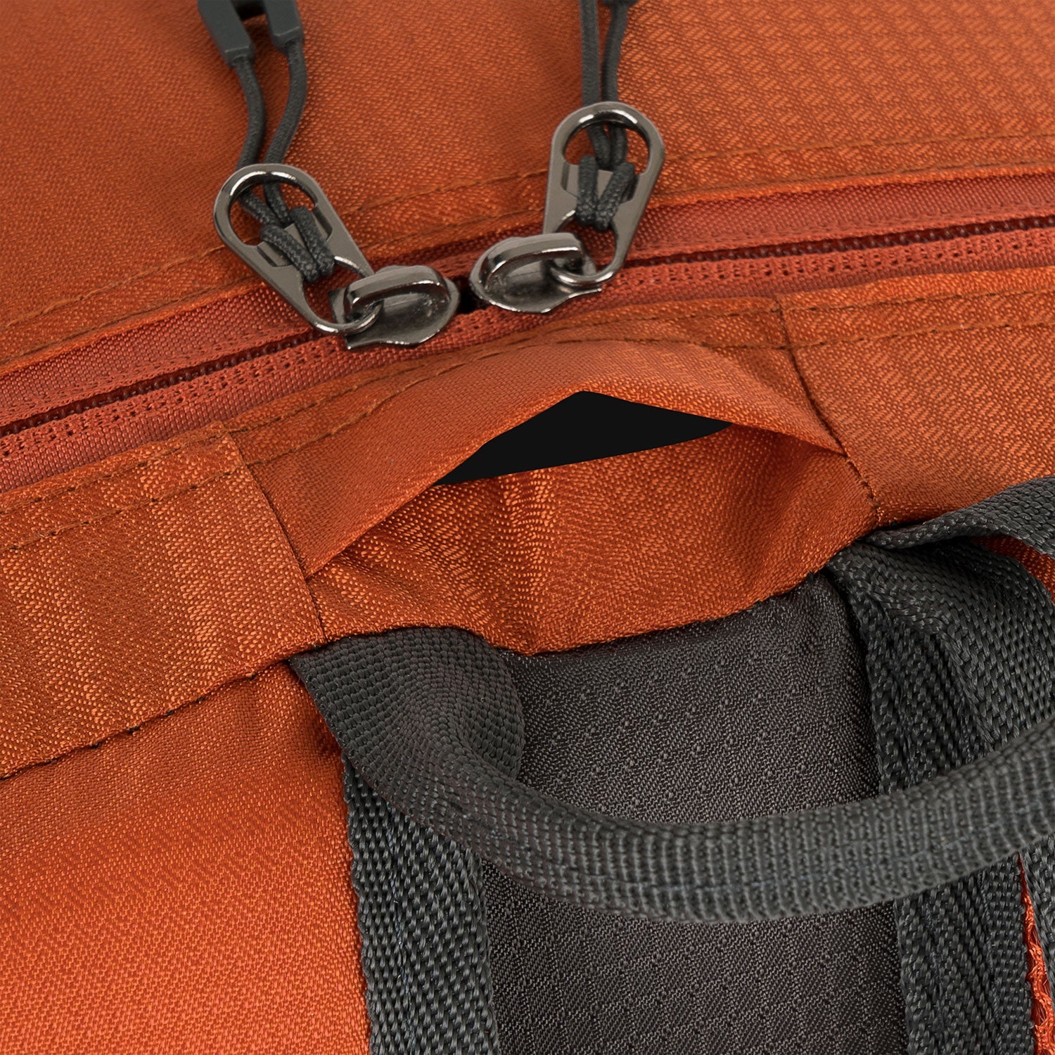 Close-up of the zipper and drawcord system on the Highlander Venture Backpack 20L in orange.