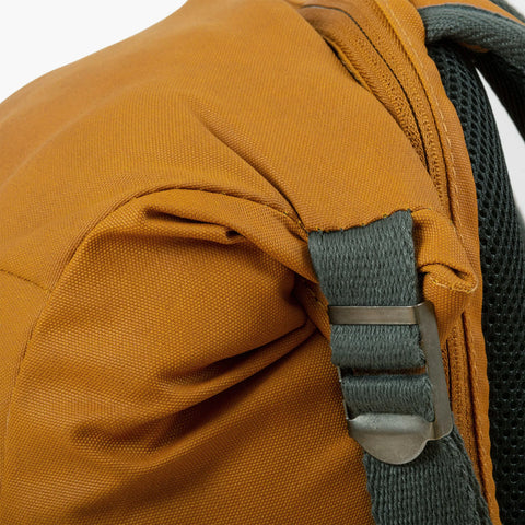 Close-up of Flug Urban Laptop Backpack shoulder strap, showcasing durable materials and stylish design in orange.