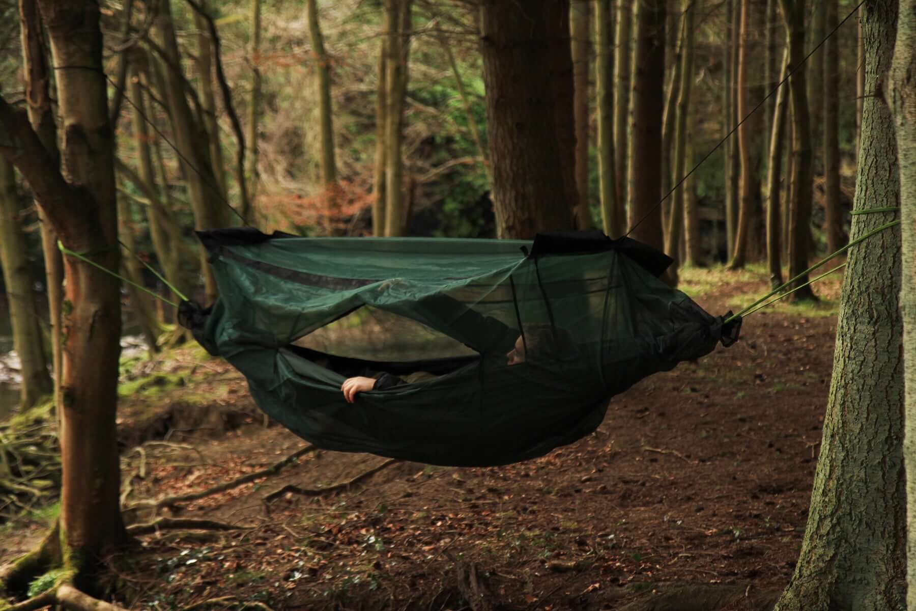 DD Hammock Mosquito Net offering insect protection in a forest setting, featuring zippered entry and secure closure.