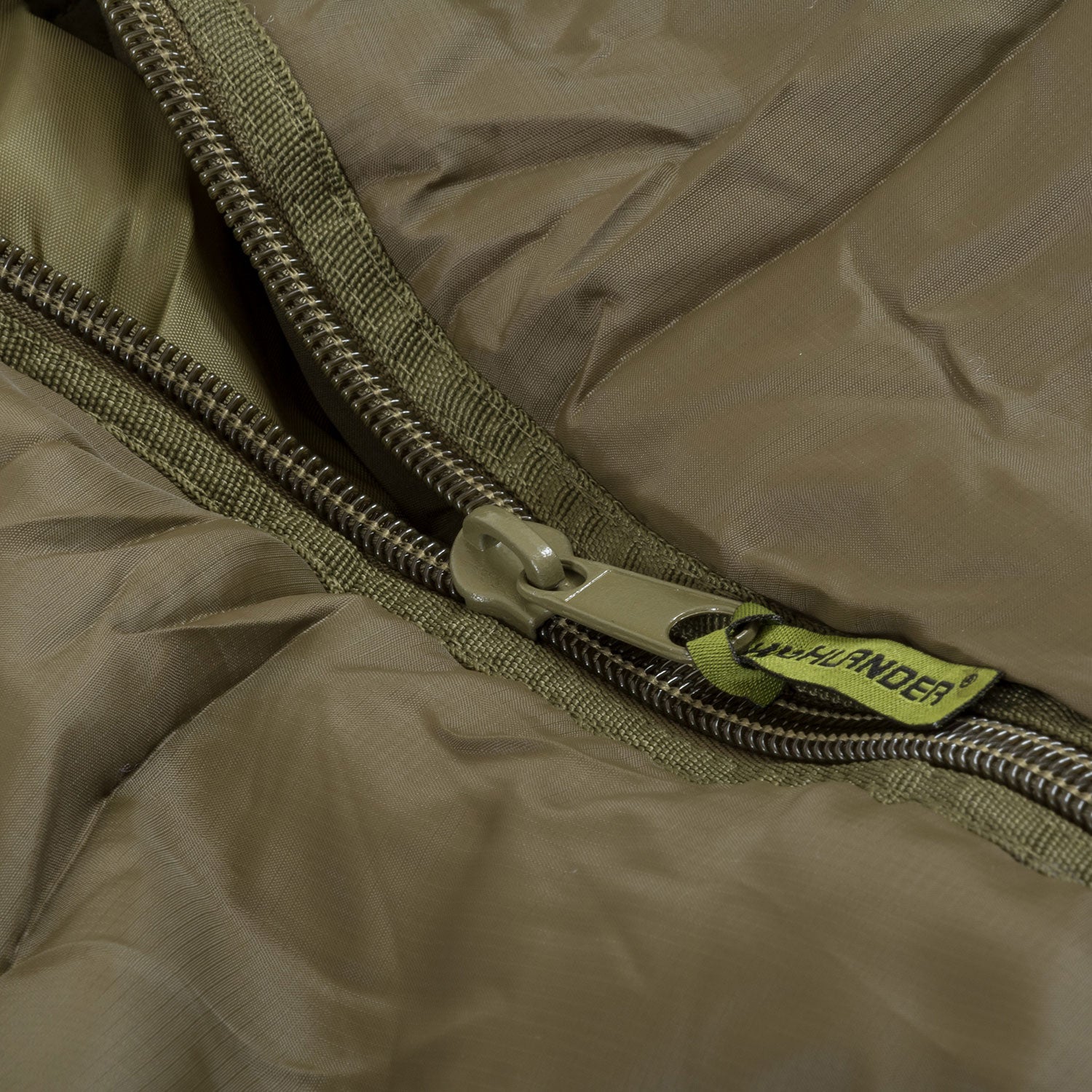 Close-up of Challenger 400 mummy sleeping bag zipper with ripstop nylon fabric and brand tag, ideal for winter camping.