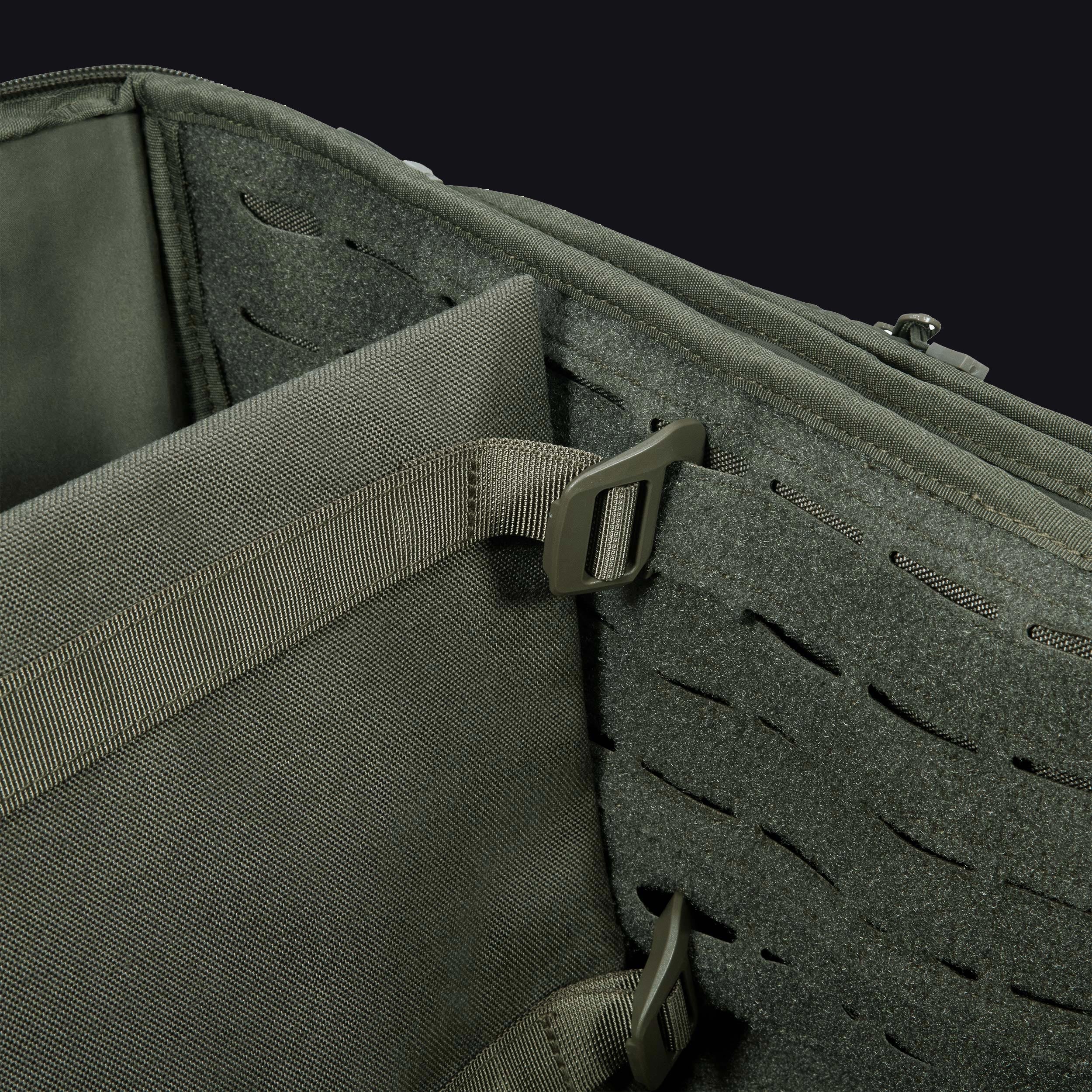 Close-up of a tactical pouch with a buckle and MOLLE webbing on a black background