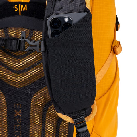 Close-up of the Skyline 12 backpack's side pocket holding a smartphone for easy access during hikes.