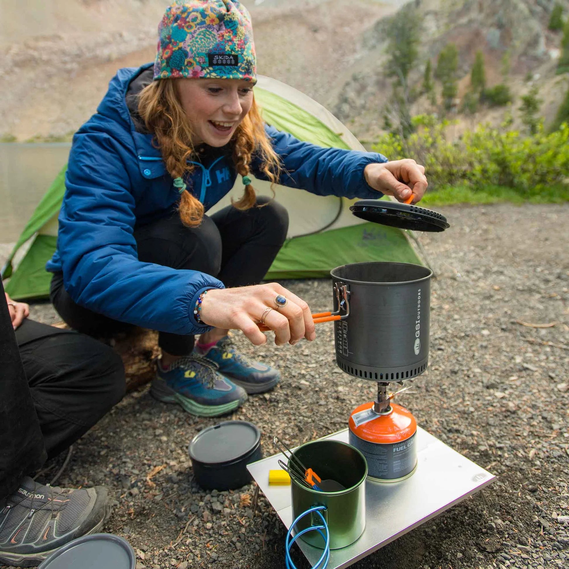 GSI Glacier camp stove being used by camper in outdoor setting