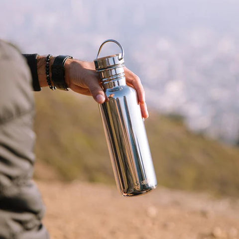 klean_kanteen_reflect_bottle_held_in_hand_showing_bamboo_lid
