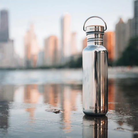 klean_kanteen_reflect_stainless_steel_water_bottle_on_city_street_with_bamboo_cap